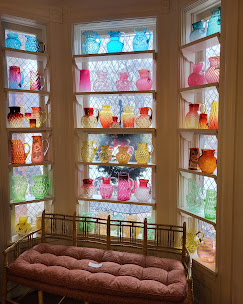 Colorful glass collection displayed in the museum bay windows